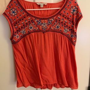 Red/orange embroidered t-shirt.